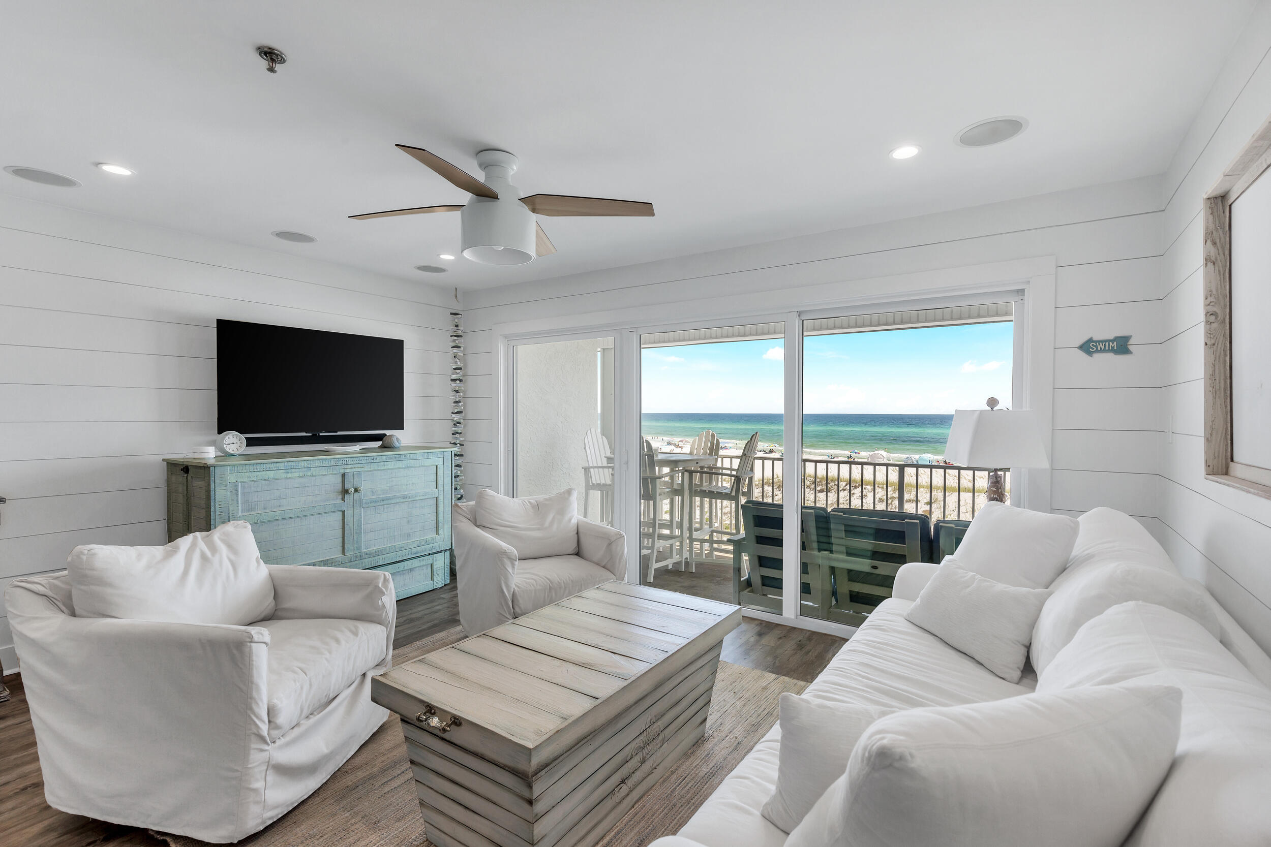 561 Eastern Lake Road, Unit 202 Santa Rosa Beach, FL 32459 - Photo 5 of 32 a living room with furniture a flat screen tv and a floor to ceiling window