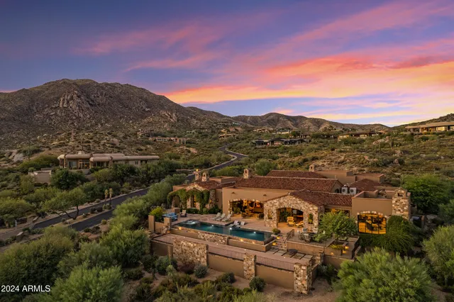 a bedroom with a bed and large windows