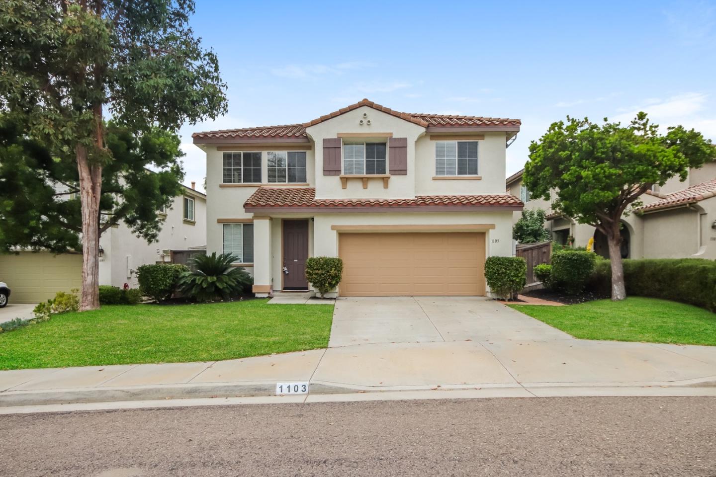 a front view of a house with a yard and garage