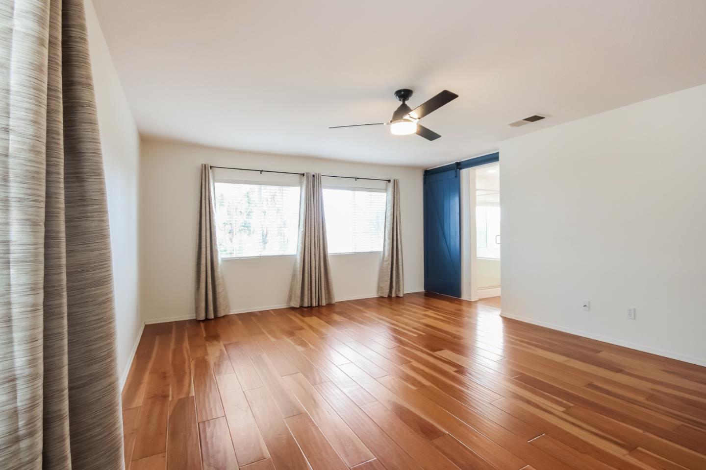 1103 Greenway Road Oceanside, CA 92057 - Photo 11 of 24 a view of an empty room with wooden floor and a window