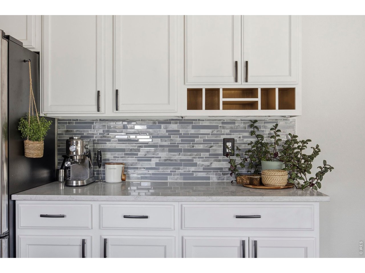 414 Prairie Clover Way Severance, CO 80550 - Photo 13 of 49 a kitchen with white cabinets a potted plant and white wooden cabinets