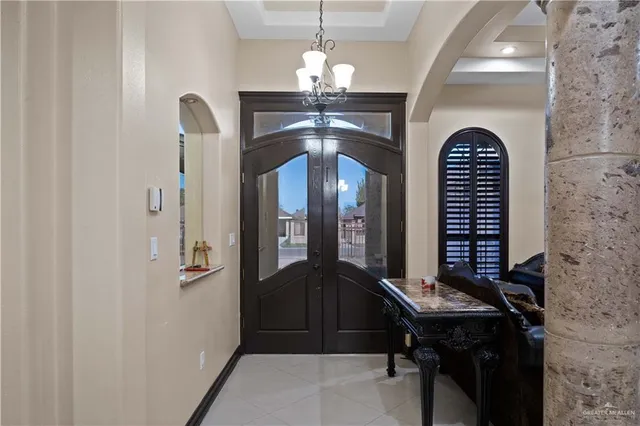 a view of a hallway with furniture and chandelier