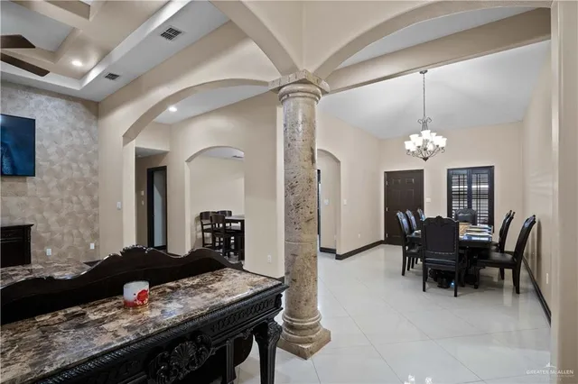 a living room with furniture a fireplace and a chandelier