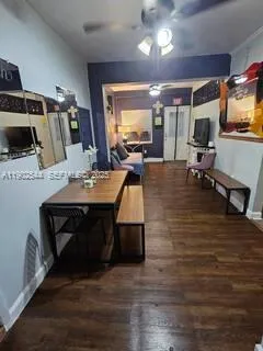 a living room with furniture a flat screen tv and kitchen view