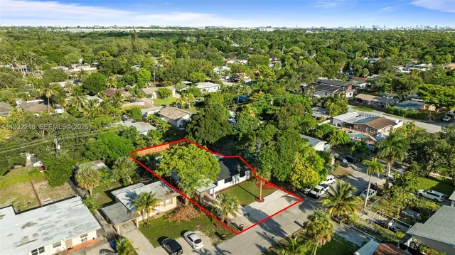an aerial view of residential houses with outdoor space and trees