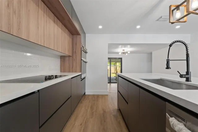 a kitchen with a sink and a stove top oven