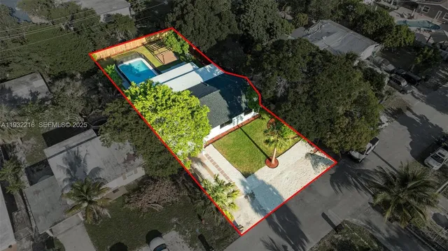 an aerial view of residential houses with outdoor space and trees