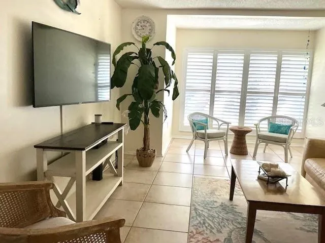 a living room with furniture a flat screen tv and a floor to ceiling window