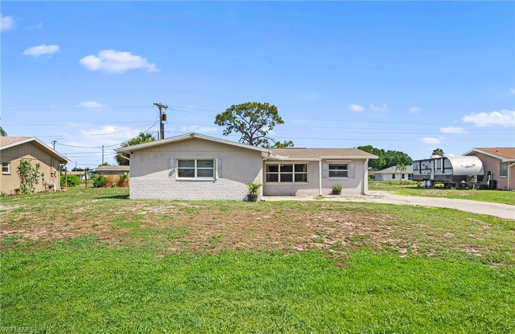 7289 Barragan Road Fort Myers, FL 33967 - Photo 1 of 18 Single-story residence featuring a neutral exterior, multiple windows, and a paved driveway