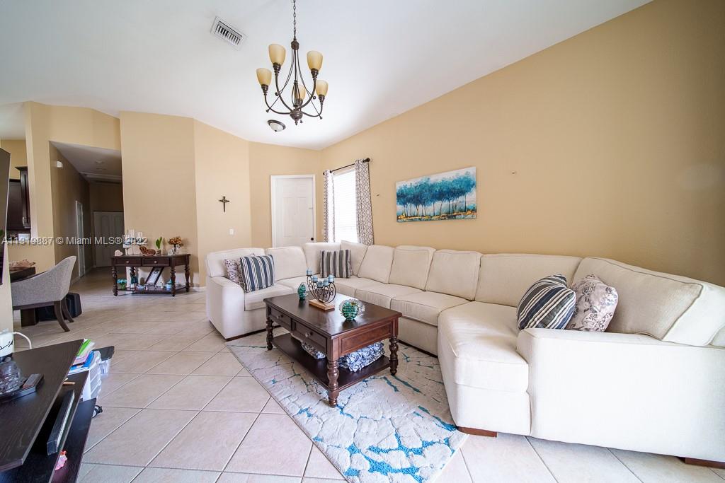 2306 Northeast 37th Road Homestead, FL 33033 - Photo 4 of 17 a living room with furniture a rug and a chandelier