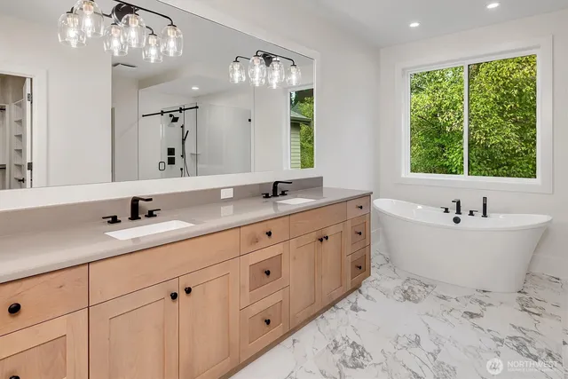 a bathroom with double vanity sink a mirror and a bathtub