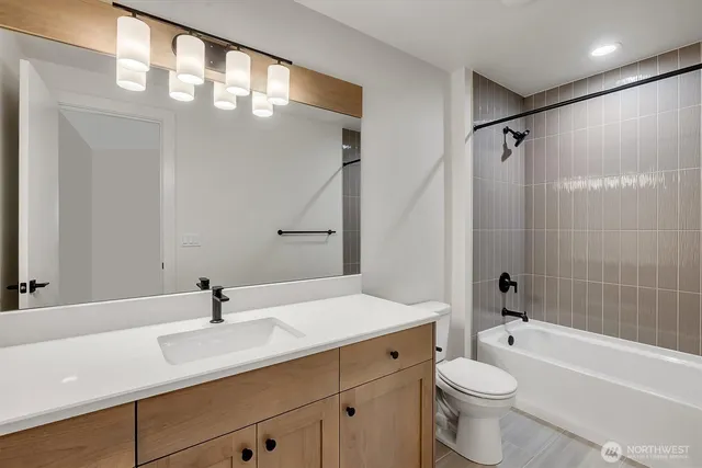 a bathroom with a sink a toilet and a large mirror