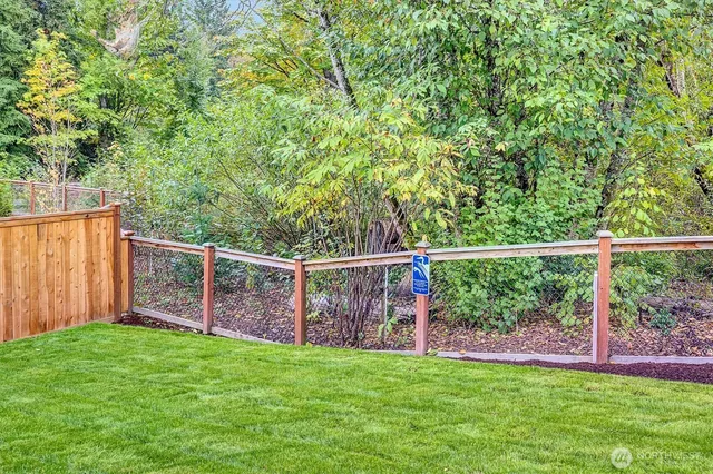 a view of a backyard with floor to ceiling window and wooden fence