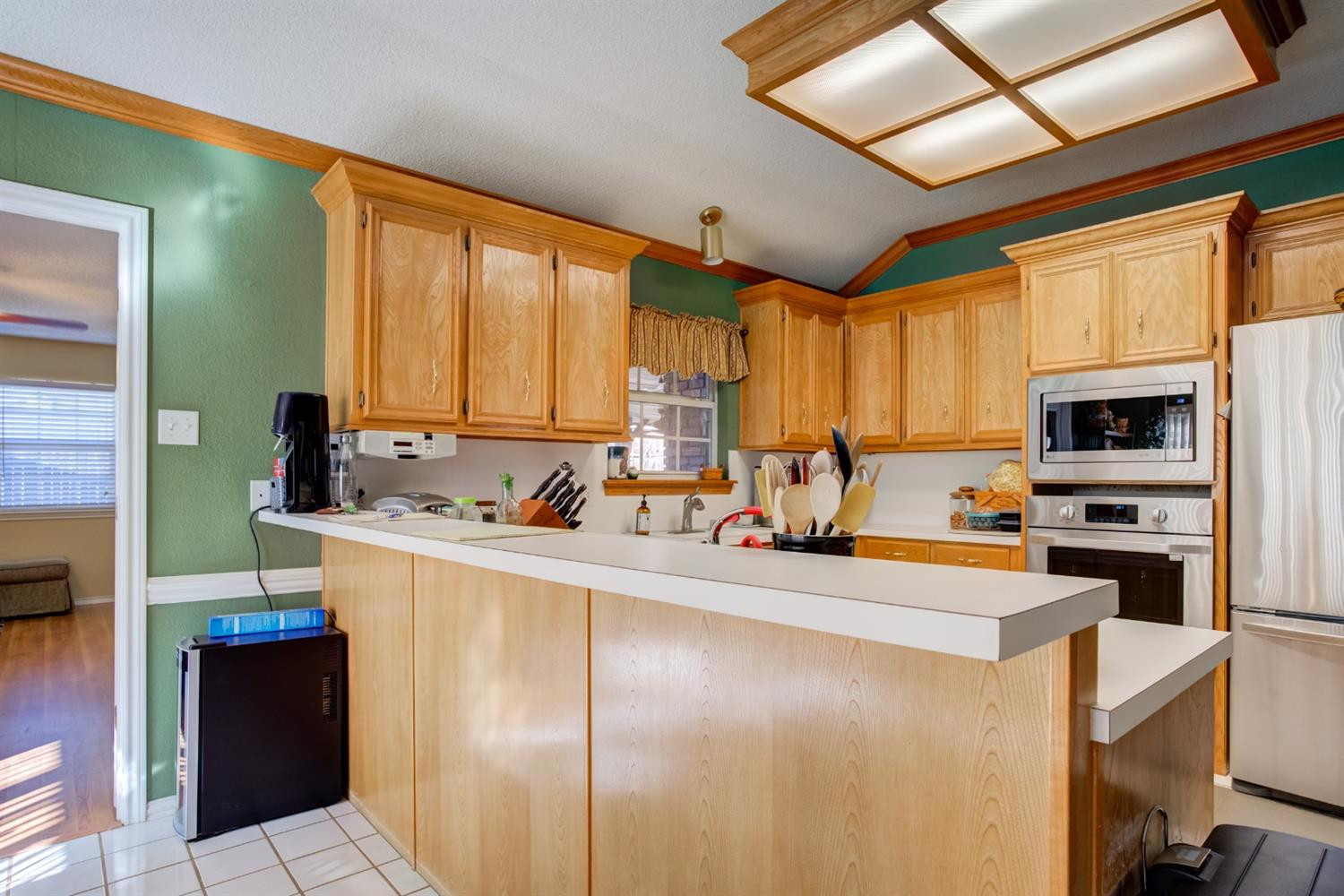 6022 78th Street Lubbock, TX 79424 - Photo 19 of 43 a kitchen with stainless steel appliances a refrigerator sink stove microwave and cabinets