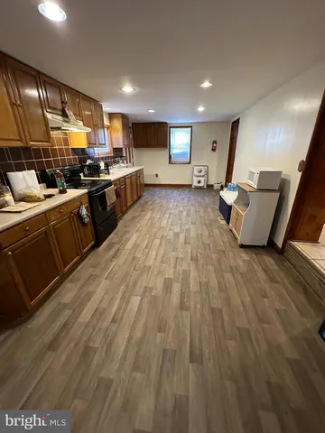 a view of a hallway with stairs and wooden floor