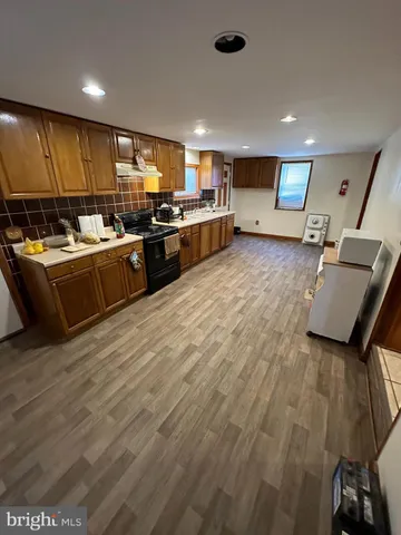 a view of a hallway with wooden floor and stairs