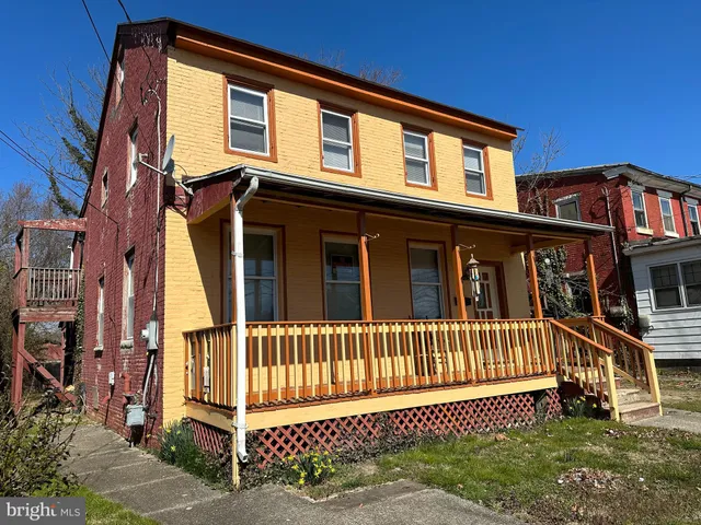 a view of a house with a small yard and wooden fence
