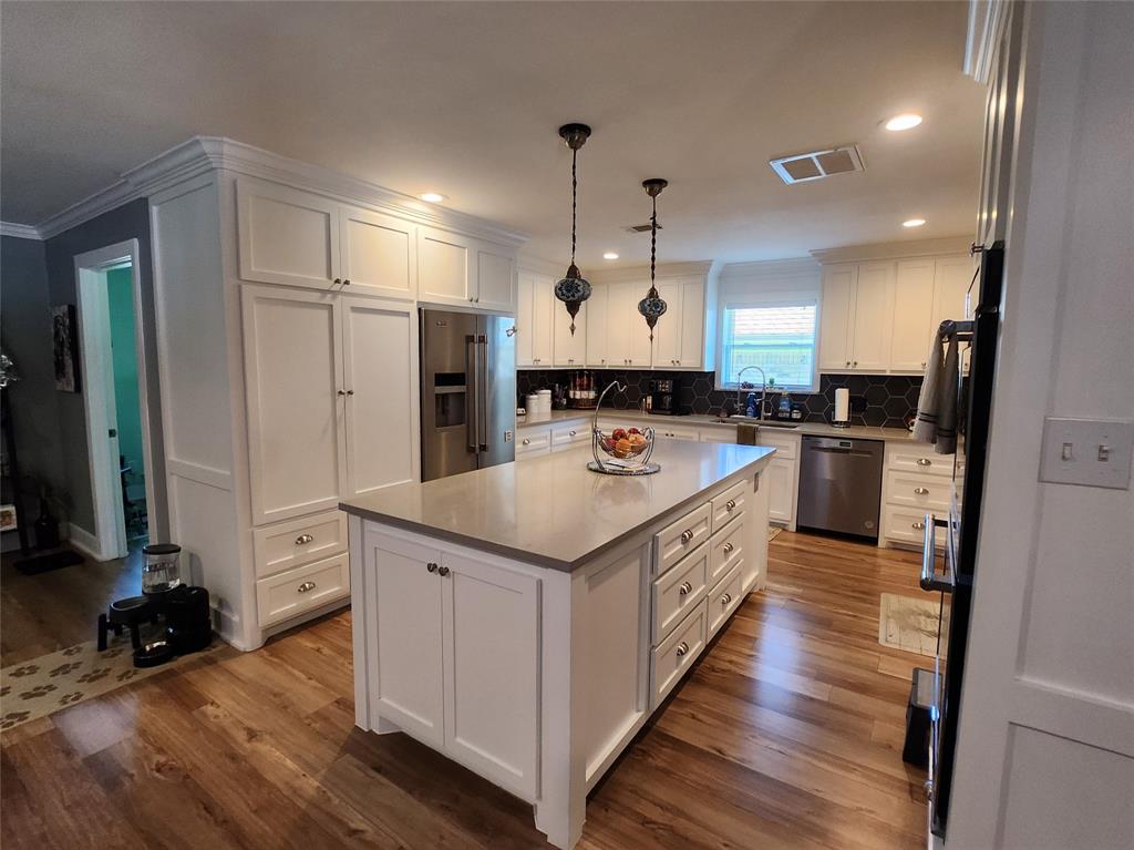 1023 Ridgefield Drive Plano, TX 75075 - Photo 17 of 39 a large kitchen with stainless steel appliances lots of counter space and wooden floor