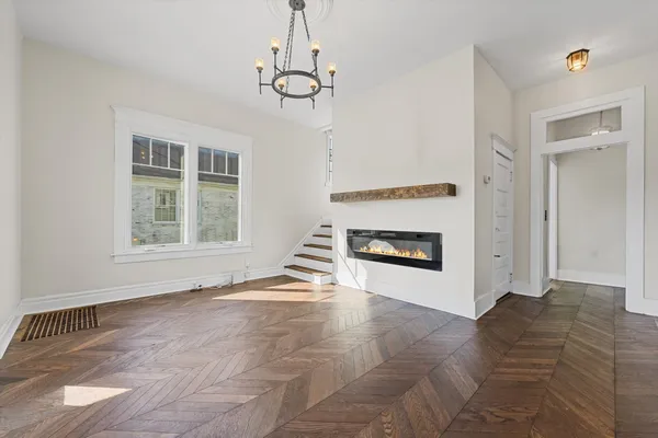 a view of an empty room with a window and fireplace