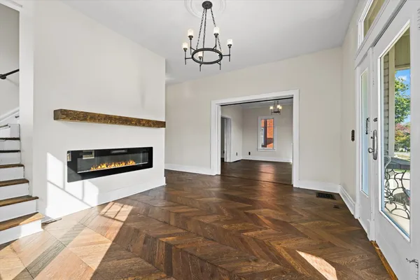 a view of a livingroom with wooden floor a fireplace and window