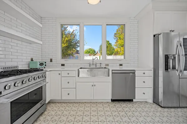 a kitchen with stainless steel appliances a stove a refrigerator and a sink