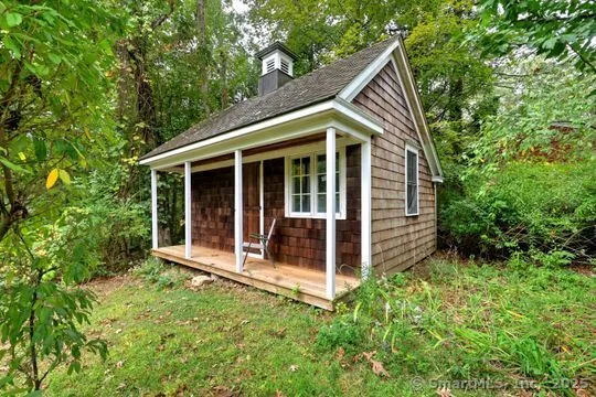 a view of house with backyard and glass windows
