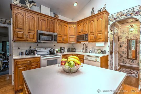 161 Jockey Hollow Road Monroe, CT 06468 - Photo 9 of 37 a kitchen with stainless steel appliances granite countertop a refrigerator a stove top oven a sink dishwasher and white cabinets with wooden floor