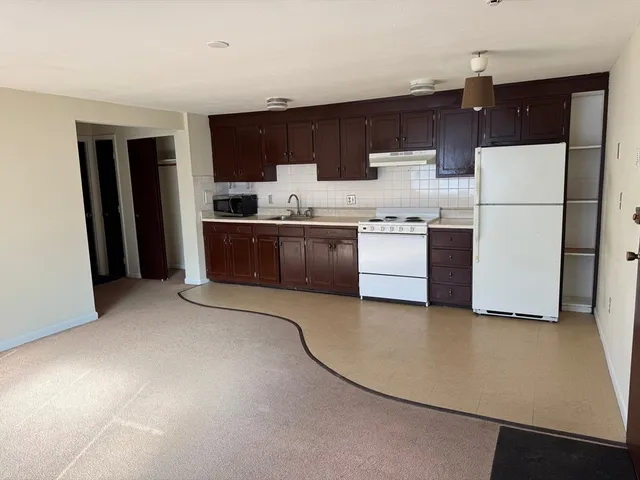 a kitchen with stainless steel appliances granite countertop a refrigerator a stove top oven a sink and dishwasher