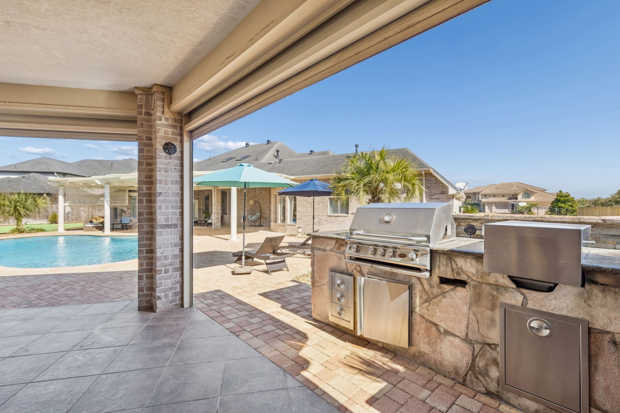 2202 Britton Ridge Drive Katy, TX 77494 - Photo 32 of 41 Seamless indoor-outdoor entertaining with the fully equipped built-in grill and prep station, perfectly positioned within the covered outdoor living area and overlooking the resort-style pool—ideal for hosting, grilling, and enjoying the backyard year-round.