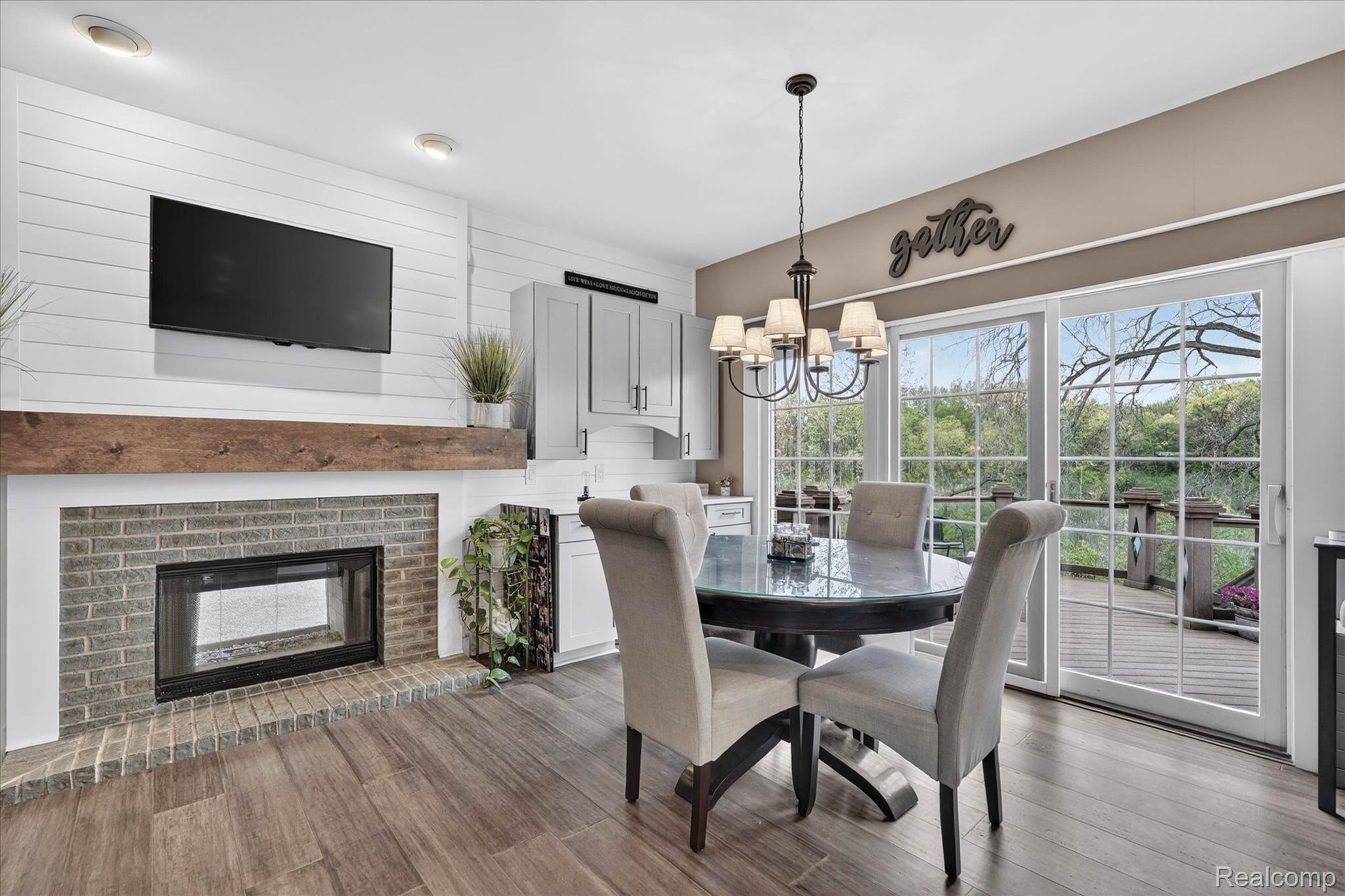9074 Ridgefield Drive Brighton, MI 48114 - Photo 14 of 75 Dining area featuring wood finished floors, hanging lights, and a brick fireplace