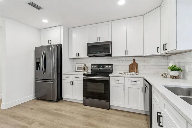 a living room with furniture a rug and wall paintings