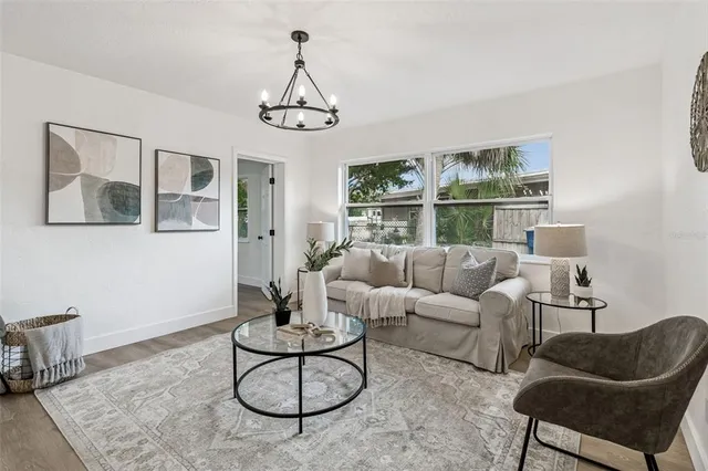 a view of an empty room and chandelier fan