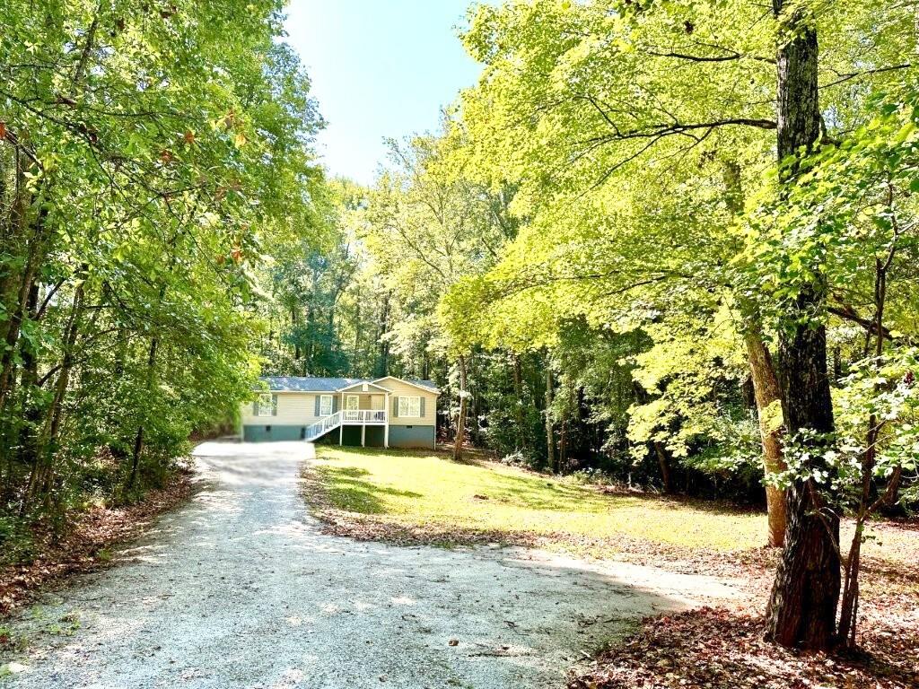 766 Country Club Road Newnan, GA 30263 - Photo 2 of 34 View of front of property with driveway, a view of trees, and a front lawn