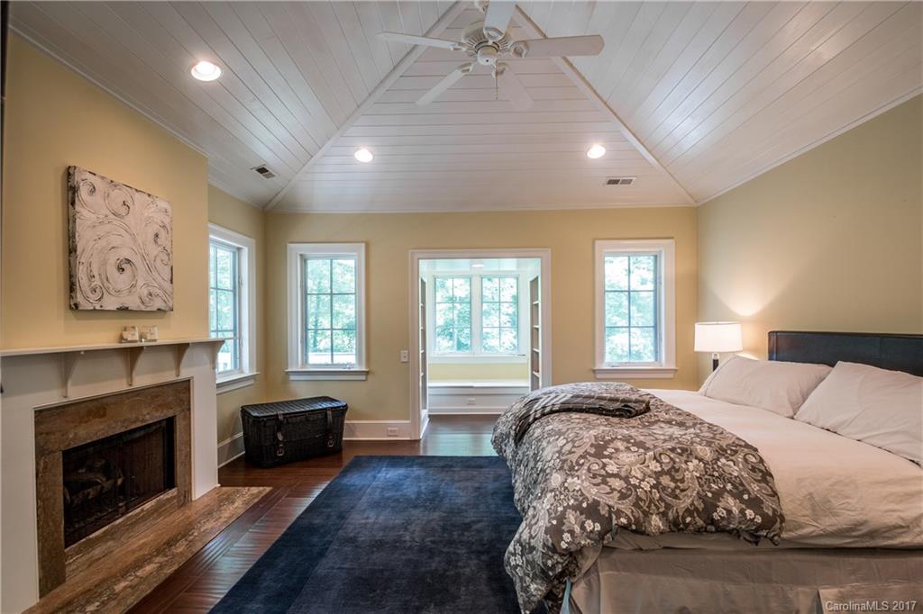 2141 Sagamore Road Charlotte, NC 28209 - Photo 6 of 24 a spacious bedroom with a large bed a fireplace and windows