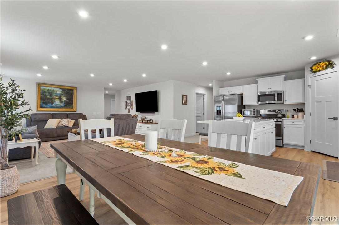 8106 West Danube Loop New Kent, VA 23124 - Photo 11 of 48 a living room with kitchen island furniture and a kitchen view