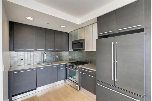 a kitchen with a sink stainless steel appliances and cabinets