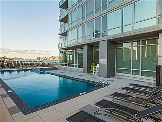 a swimming pool with barbeque oven in front of it