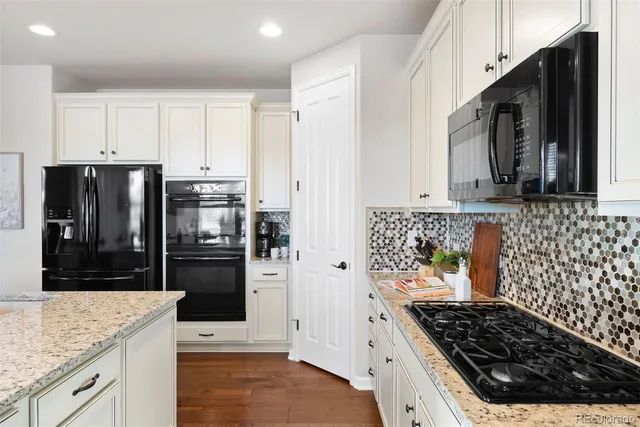a kitchen with granite countertop a refrigerator and a sink