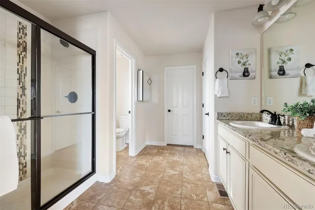 a spacious bathroom with a granite countertop sink mirror and shower
