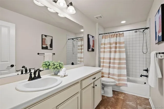 a bathroom with a sink a toilet a tub and shower