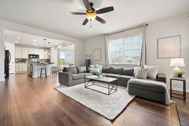 a living room with furniture wooden floor and a large window