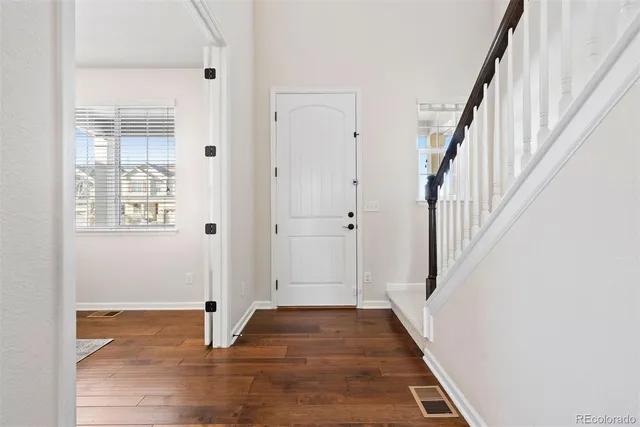 a view of a hallway with wooden floor and staircase
