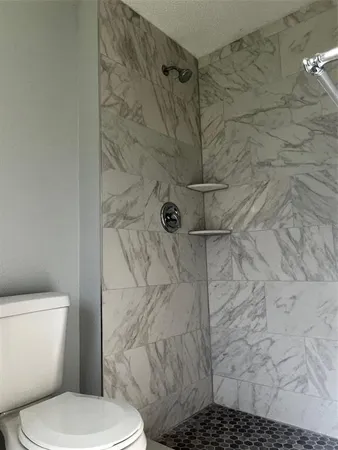 a white toilet sitting next to a shower curtain
