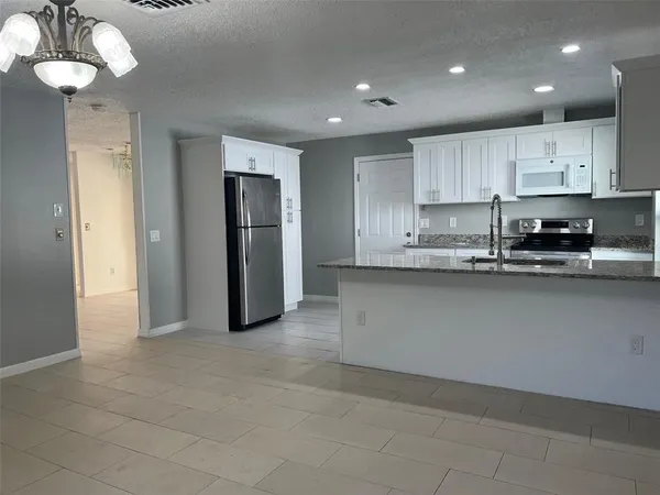 a kitchen with stainless steel appliances granite countertop a refrigerator sink and cabinets