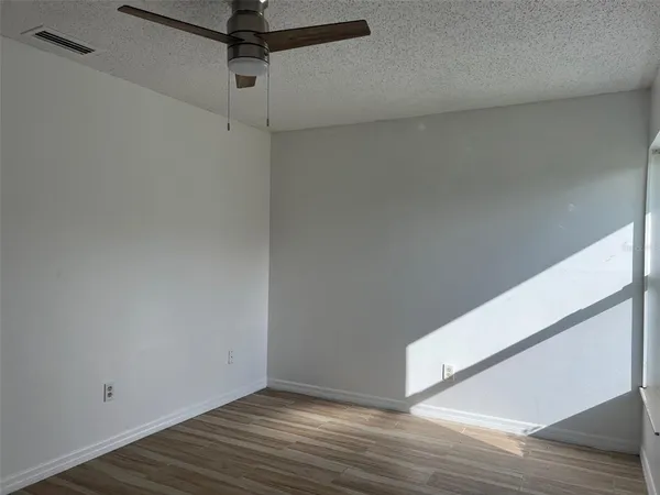 a view of an empty room with wooden floor