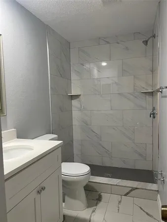 a bathroom with a toilet a sink and shower