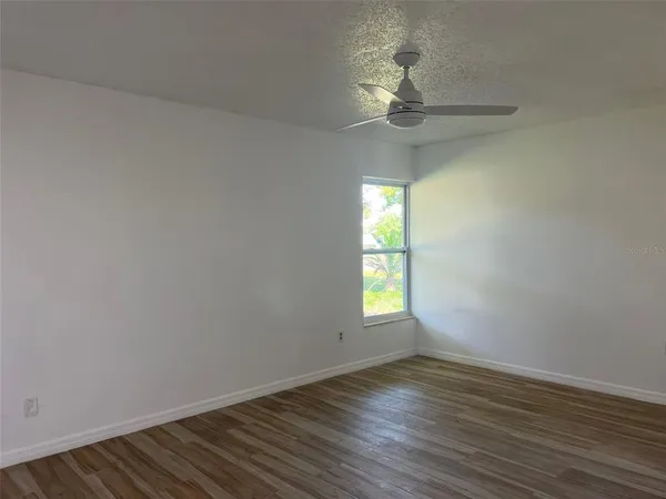 wooden floor in an empty room with a window