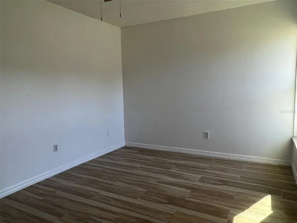 a view of an empty room with wooden floor