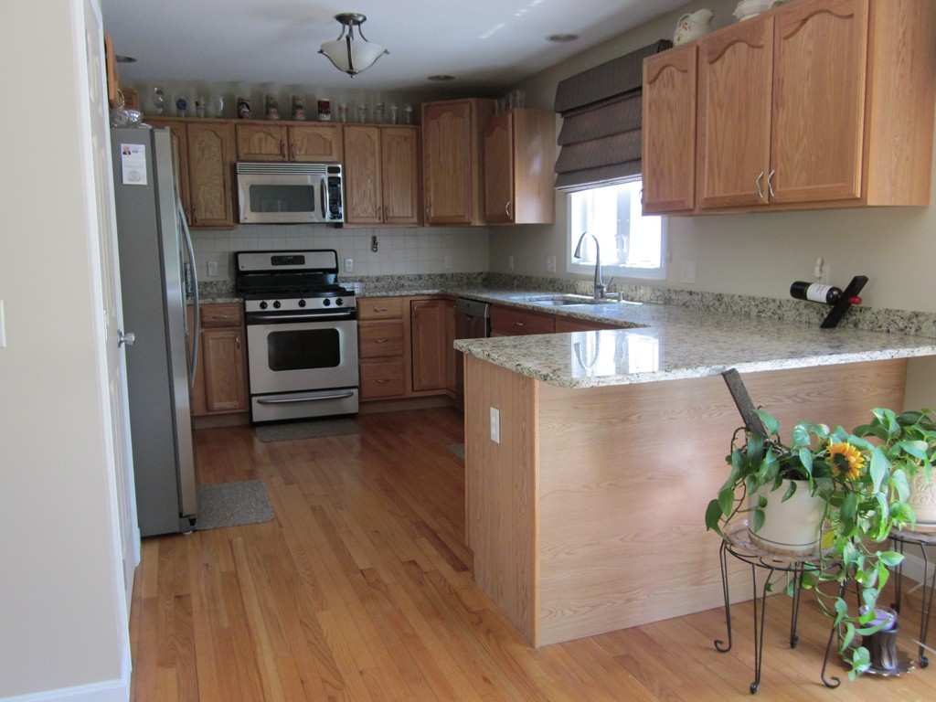5 Woodland Road Springfield, MA 01129 - Photo 11 of 30 a kitchen with kitchen island granite countertop a sink cabinets and stainless steel appliances