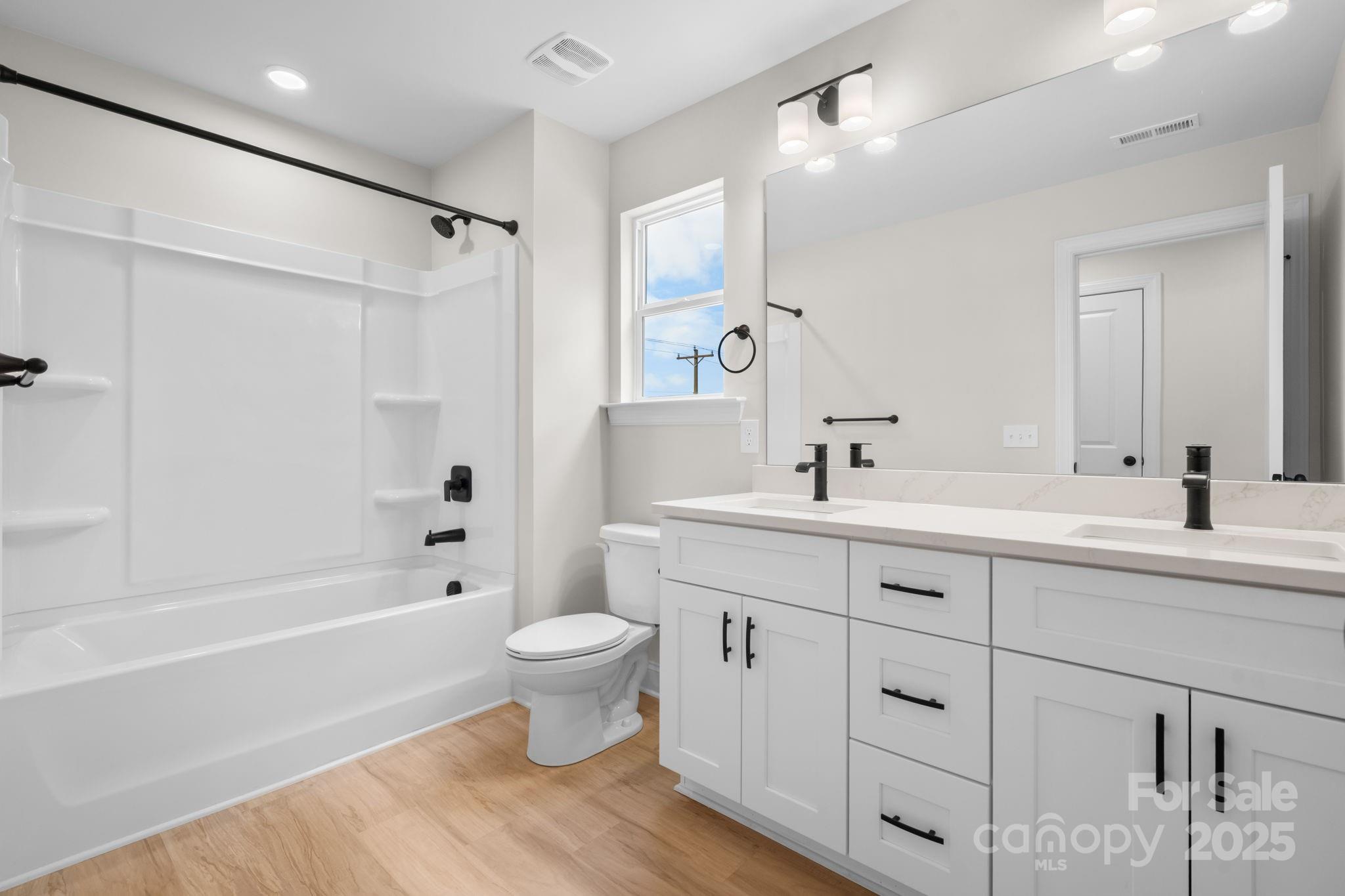 1888 Sigmon Dairy Road Newton, NC 28658 - Photo 18 of 38 a bathroom with a double vanity sink a toilet and a bathtub